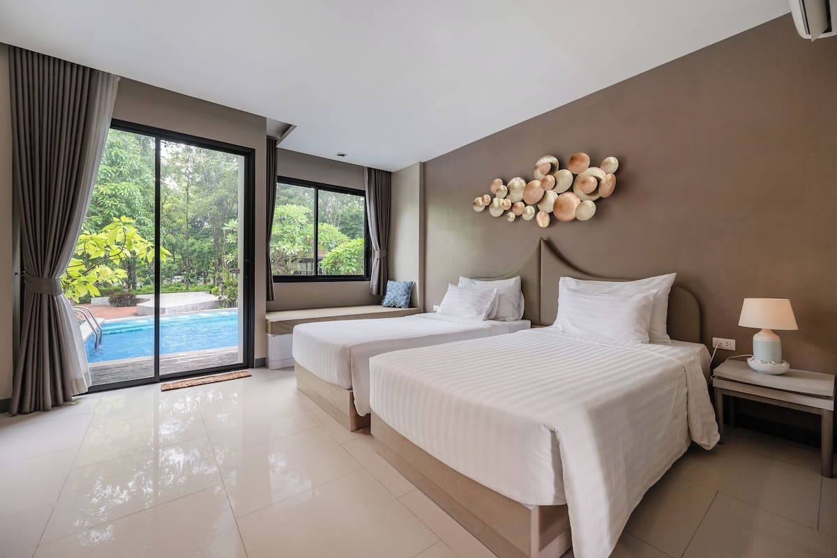 A hotel room with two beds, a view of a swimming pool, and a decorative wall piece.