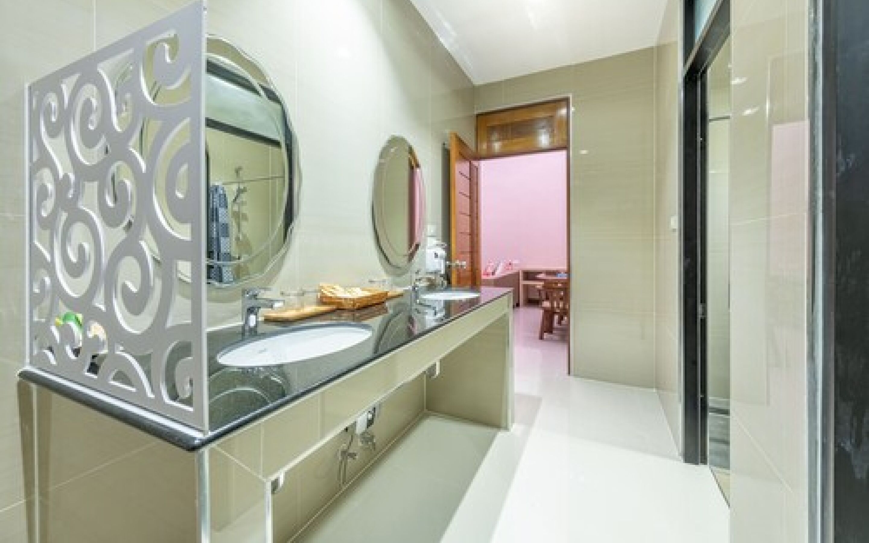 A modern bathroom with two sinks, a large mirror, and a decorative panel.