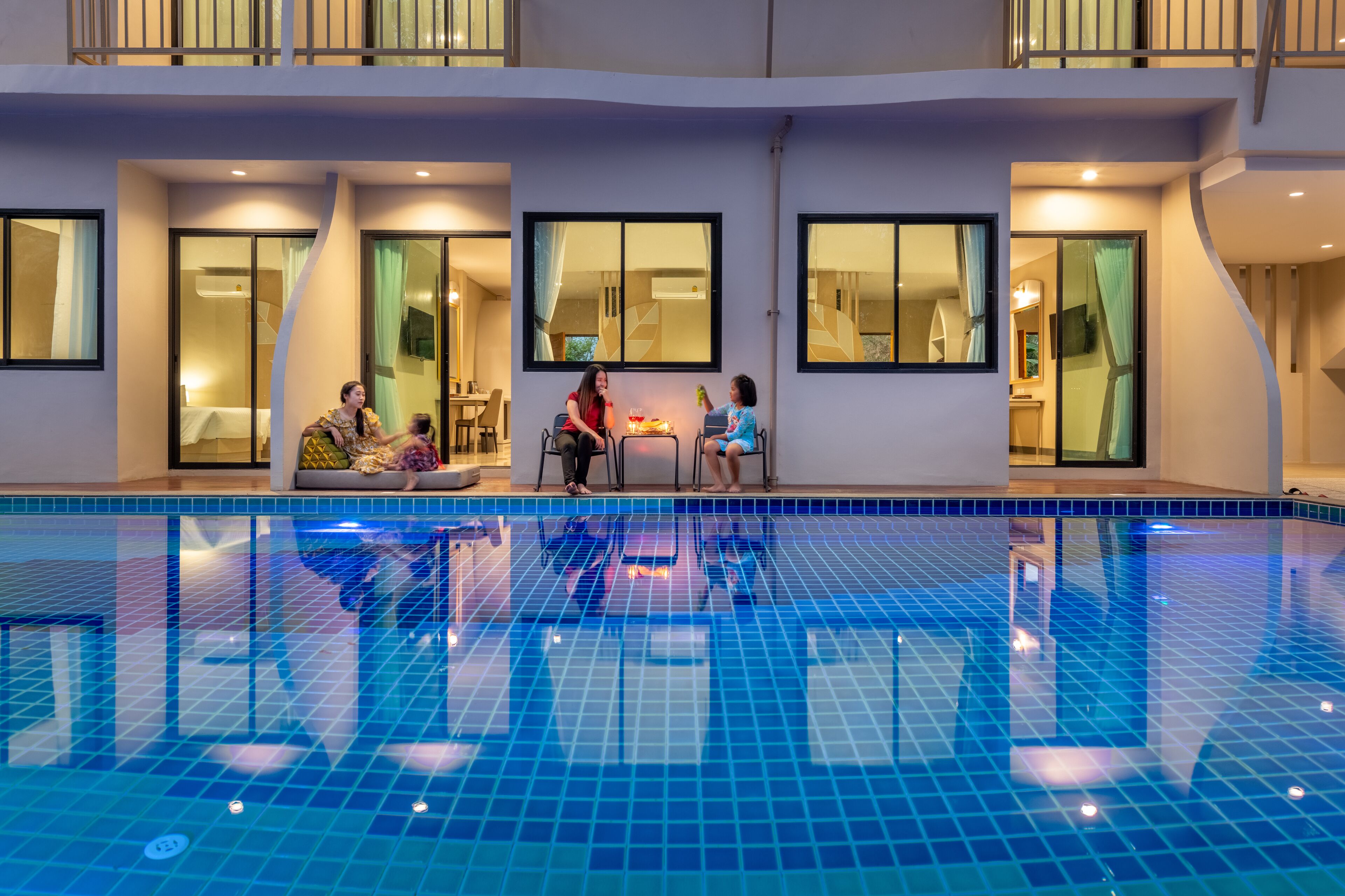Una piscina interior con paredes de azulejos y un balcón superior.