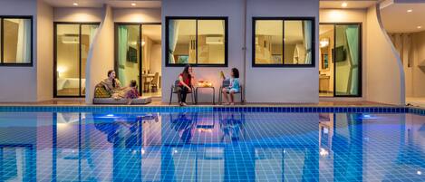 Una piscina interior con paredes de azulejos y un balcón superior.