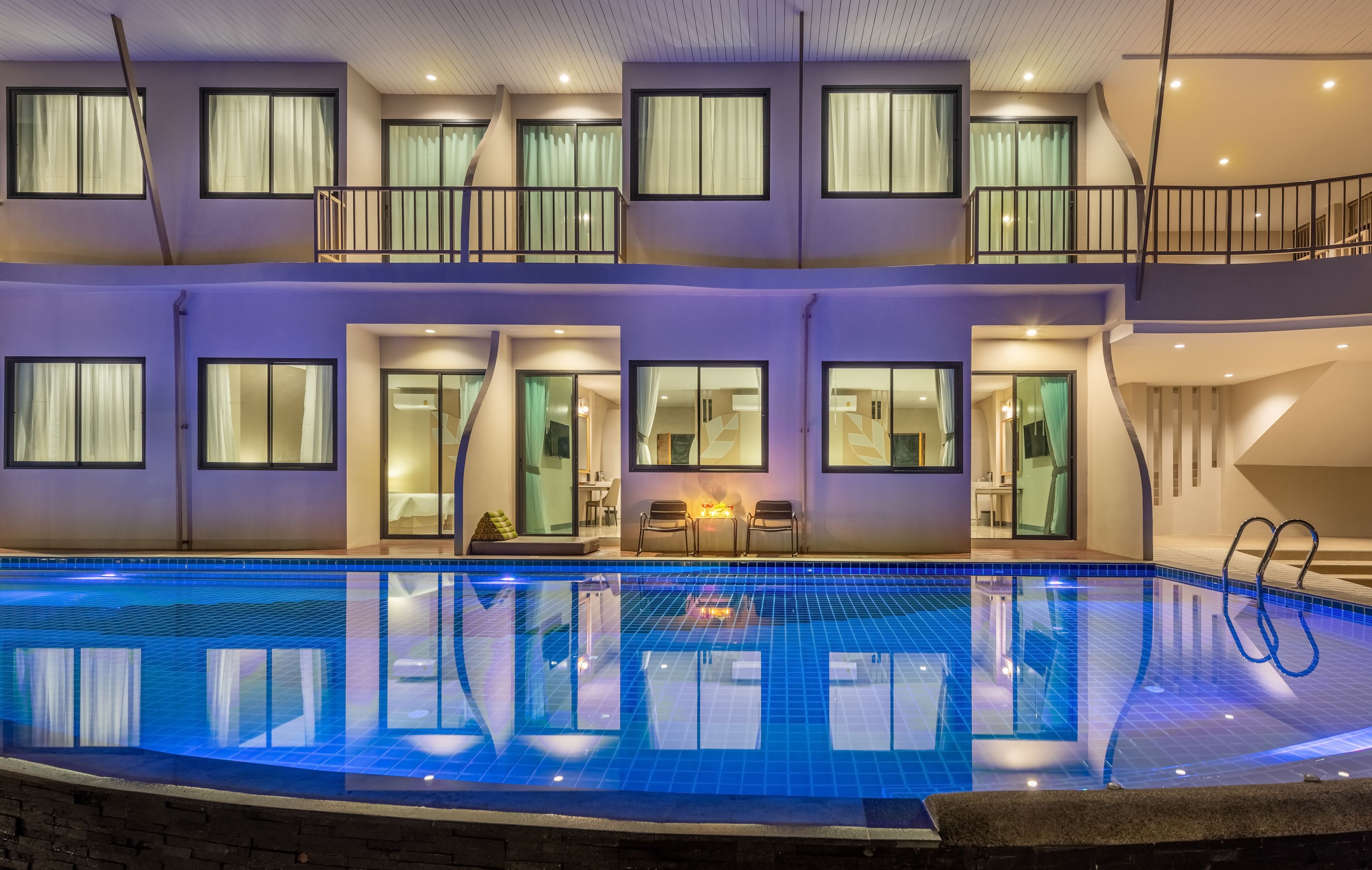 Un hotel moderno con una amplia piscina cubierta, varios balcones y un interior bien iluminado.