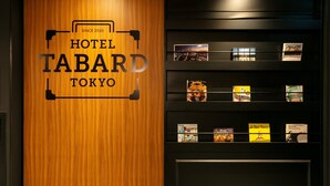 A wooden wall with the text "HOTEL TABARD TOKYO" and a display of books and postcards. - Hotel Tabard Tokyo (Tokyo)