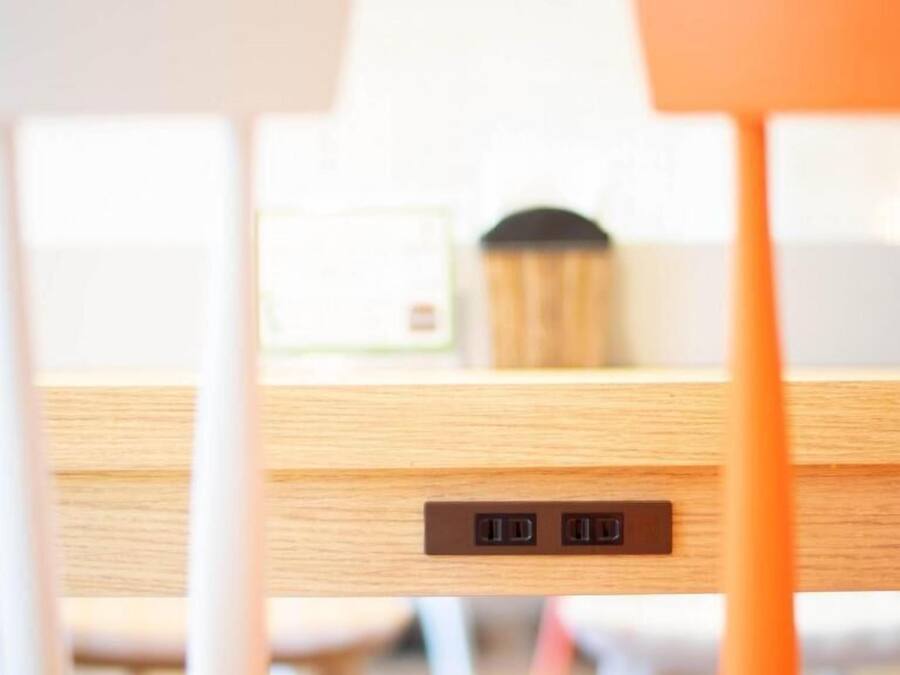 Een houten tafel met twee USB-poorten en een stopcontact.