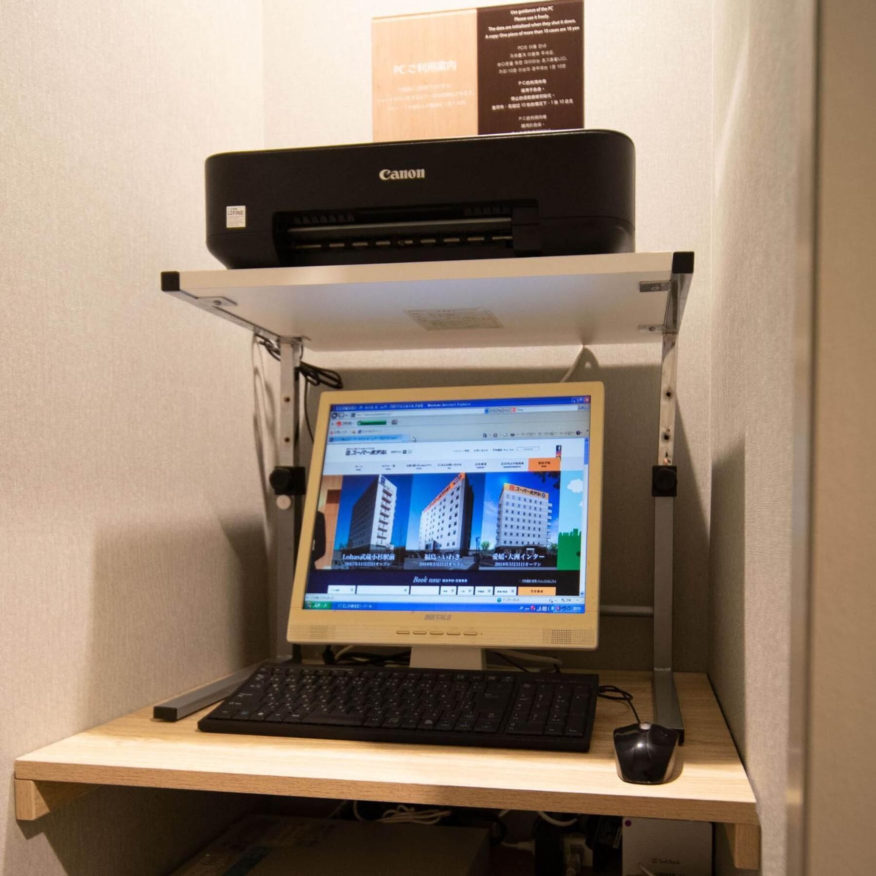 Configuração de computador com monitor, teclado e rato sobre uma secretária de madeira.