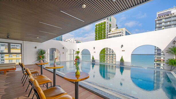 A rooftop pool area with seating and a view of surrounding buildings. - Golden Lotus Hotel Da Nang (Da Nang)