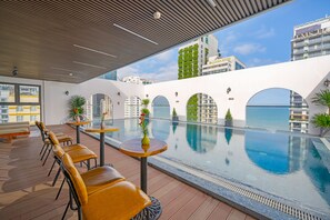 A rooftop pool area with seating and a view of surrounding buildings. - Golden Lotus Hotel Da Nang (Da Nang)