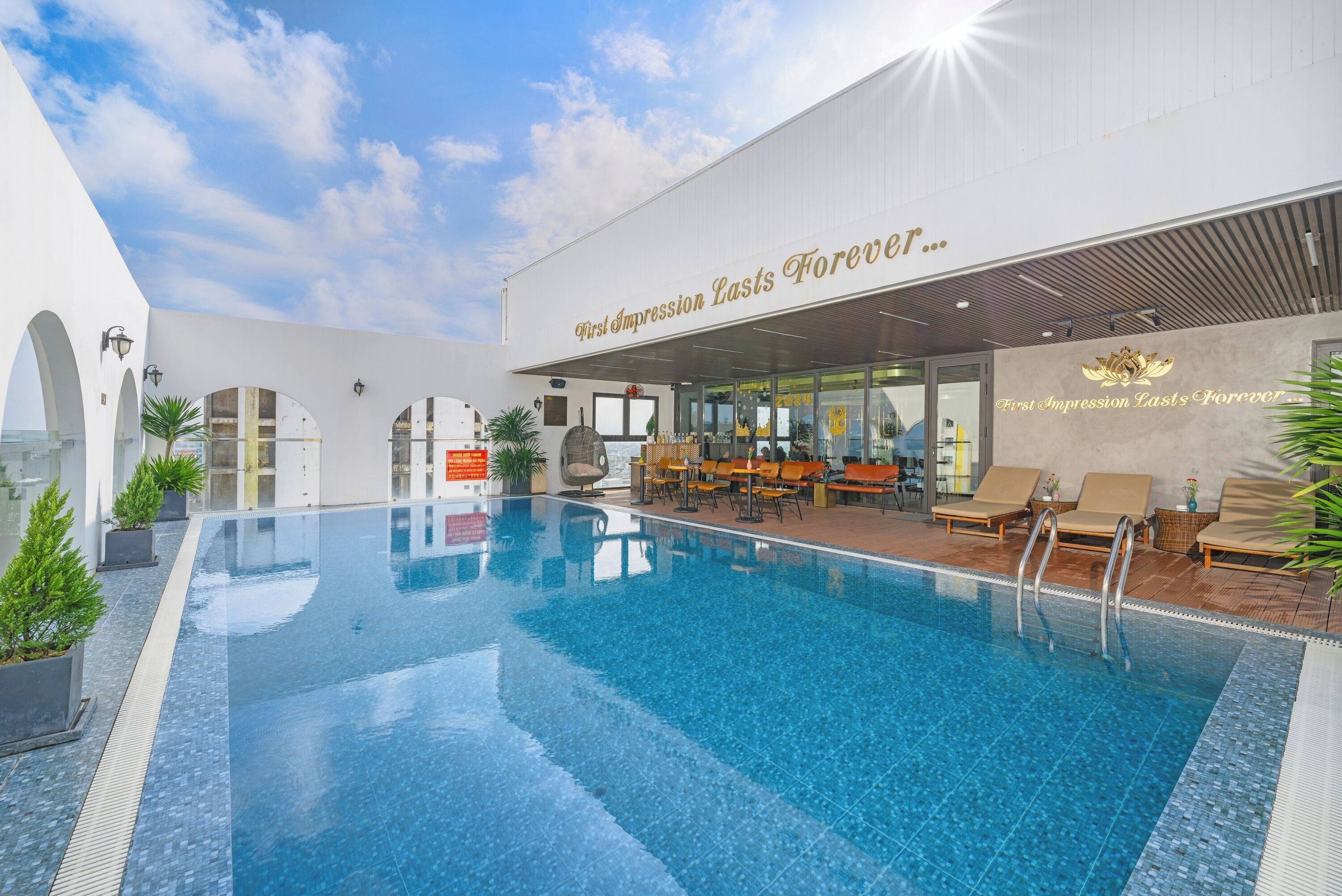 An indoor swimming pool with lounge chairs and a restaurant area.