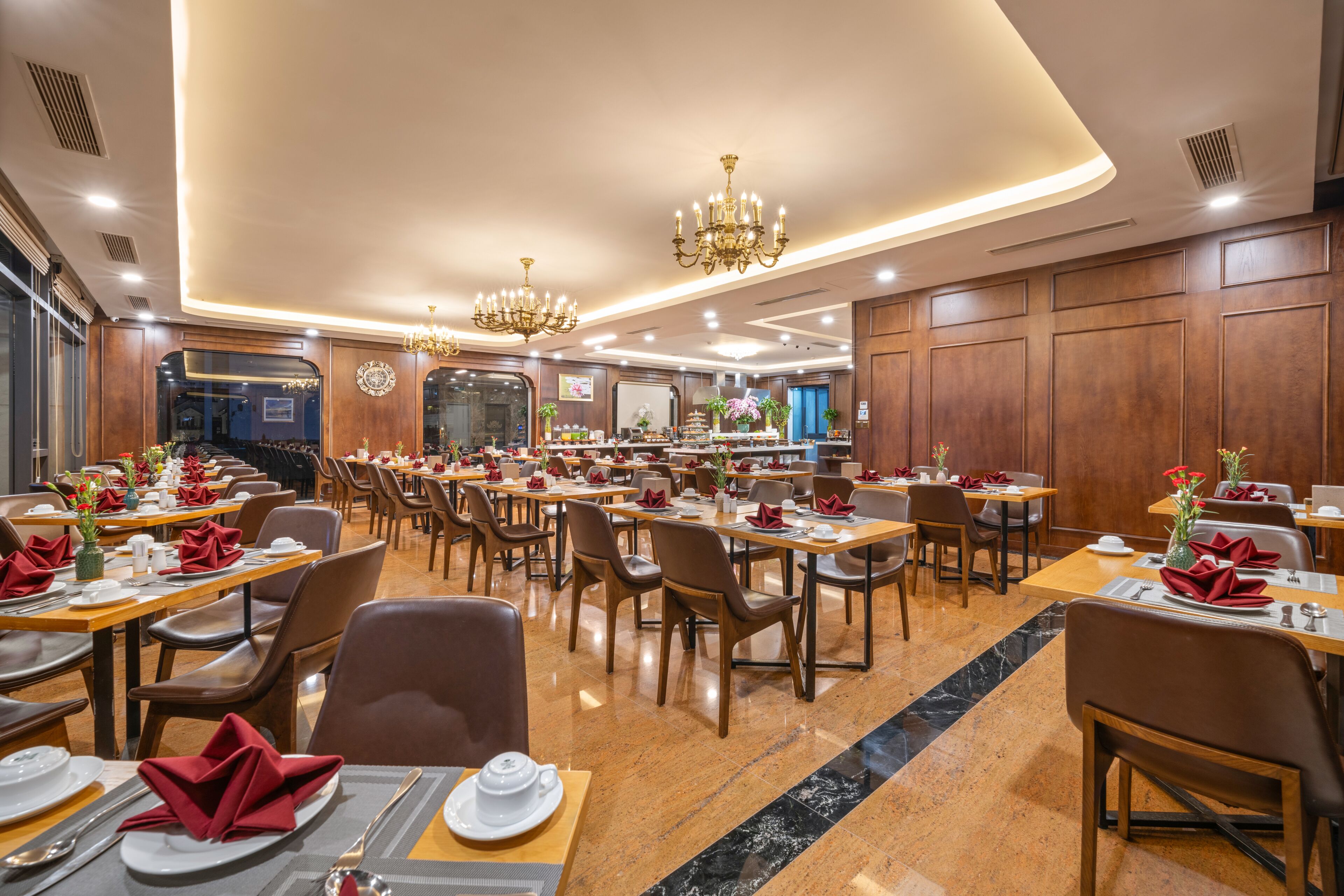 Un restaurante espacioso con varias mesas, sillas y candelabros.