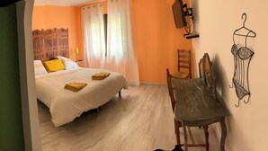 A bedroom with a bed, a chair, a dresser, and a mirror.