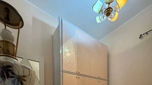 A bedroom with a bed, a wardrobe, a table, and a ceiling fan. - Villa Falaride on the sea of Licata  (Licata)