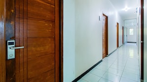 Un couloir avec des portes en bois numérotées 208 et 209, qui donnent accès à des chambres.
