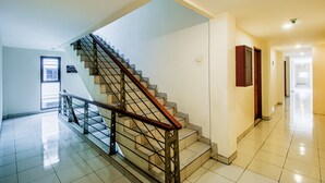 A modern interior with a staircase, a hallway, and a door. - Plaza 68 Residence (Jakarta)