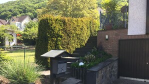Un jardin bien entretenu, agrémenté d’un banc en pierre, d’une clôture en métal et d’un portail en bois.