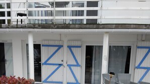 Um edifício com paredes externas brancas, portas azuis e portão.