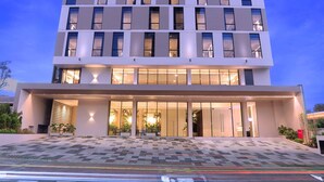 Un hotel moderno con fachada plana, ventanas amplias y un área de entrada espaciosa.
