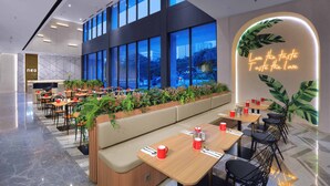 Un restaurante moderno con techos altos, ventanas amplias y un letrero de neón.