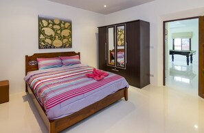Une chambre à coucher avec un lit, une armoire et un tableau accroché au mur.