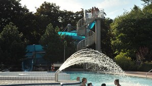 A swimming pool with a water slide and a platform. - KL17 Ostel – Hostel Döbeln (Doebeln)