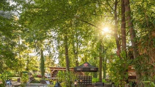 An outdoor patio area with stone seating, a small pool, and a gazebo. - KL17 Ostel – Hostel Döbeln (Doebeln)
