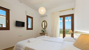 Une chambre d’hôtel avec un grand lit, une télévision, un miroir et un balcon avec des rideaux.