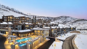 Un hotel con varias edificaciones, piscina y paisaje nevado.