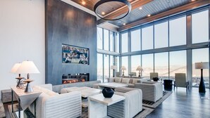 Amplia sala de estar con chimenea, ventanas grandes y muebles modernos.