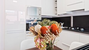 Una cocina moderna con armarios blancos, un microondas y una estufa.