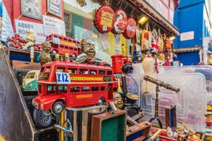 A collection of vintage toys and collectibles, including a red double-decker bus and various other items.