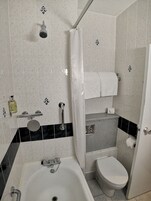 Ein Badezimmer mit Badewanne, Toilette und Duschvorhang.