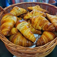 Un cesto pieno di croissant dorati e fragranti.