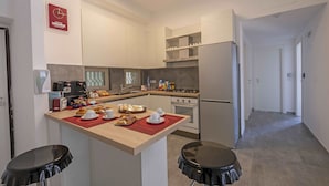 A modern kitchen with a central island, a coffee machine, and a breakfast setup.