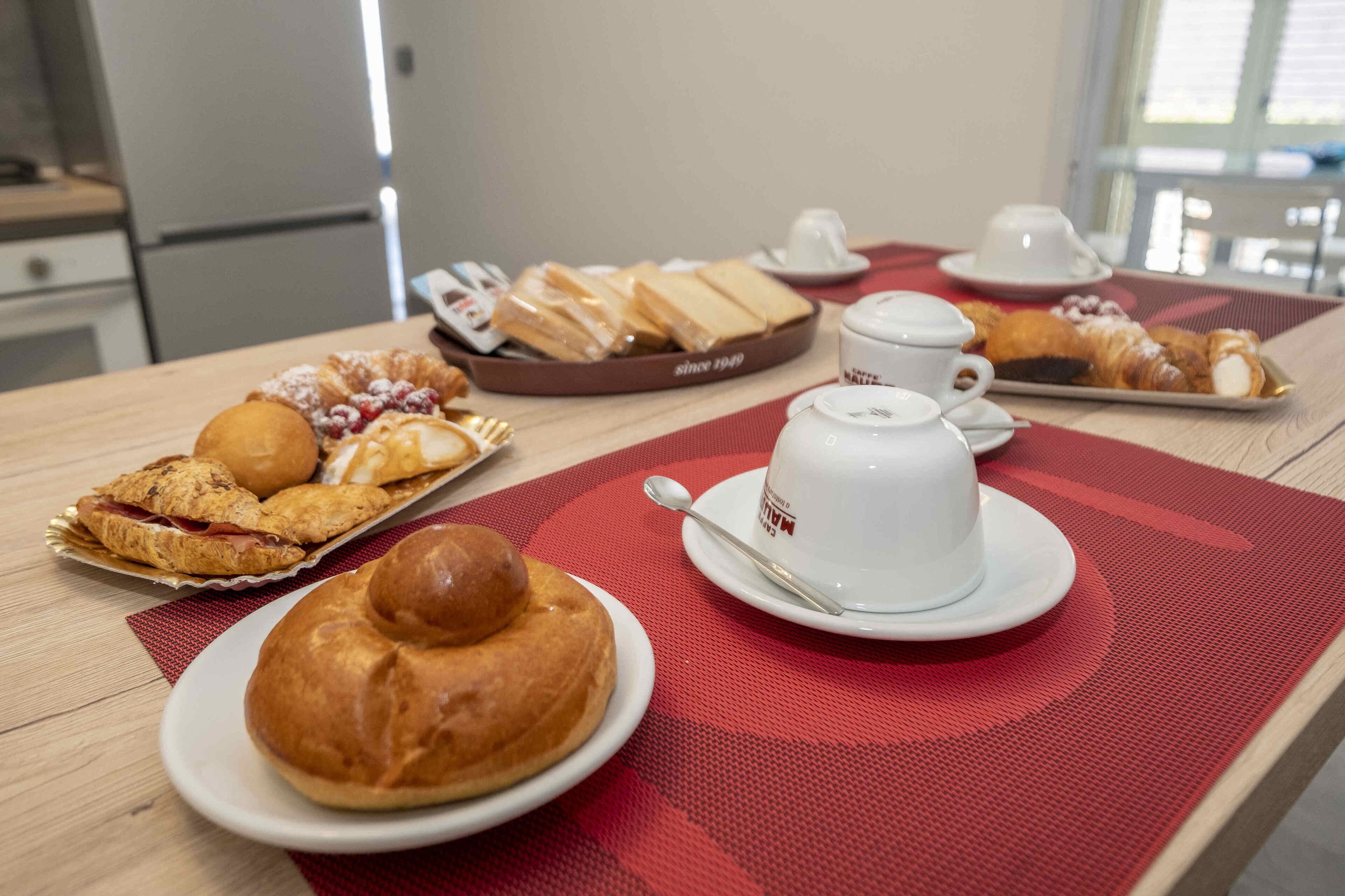 Ein Frühstückstisch mit Gebäck, Croissants und einer Kaffeetasse.