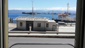 A harbor with boats, a small building, and a clear blue sky.