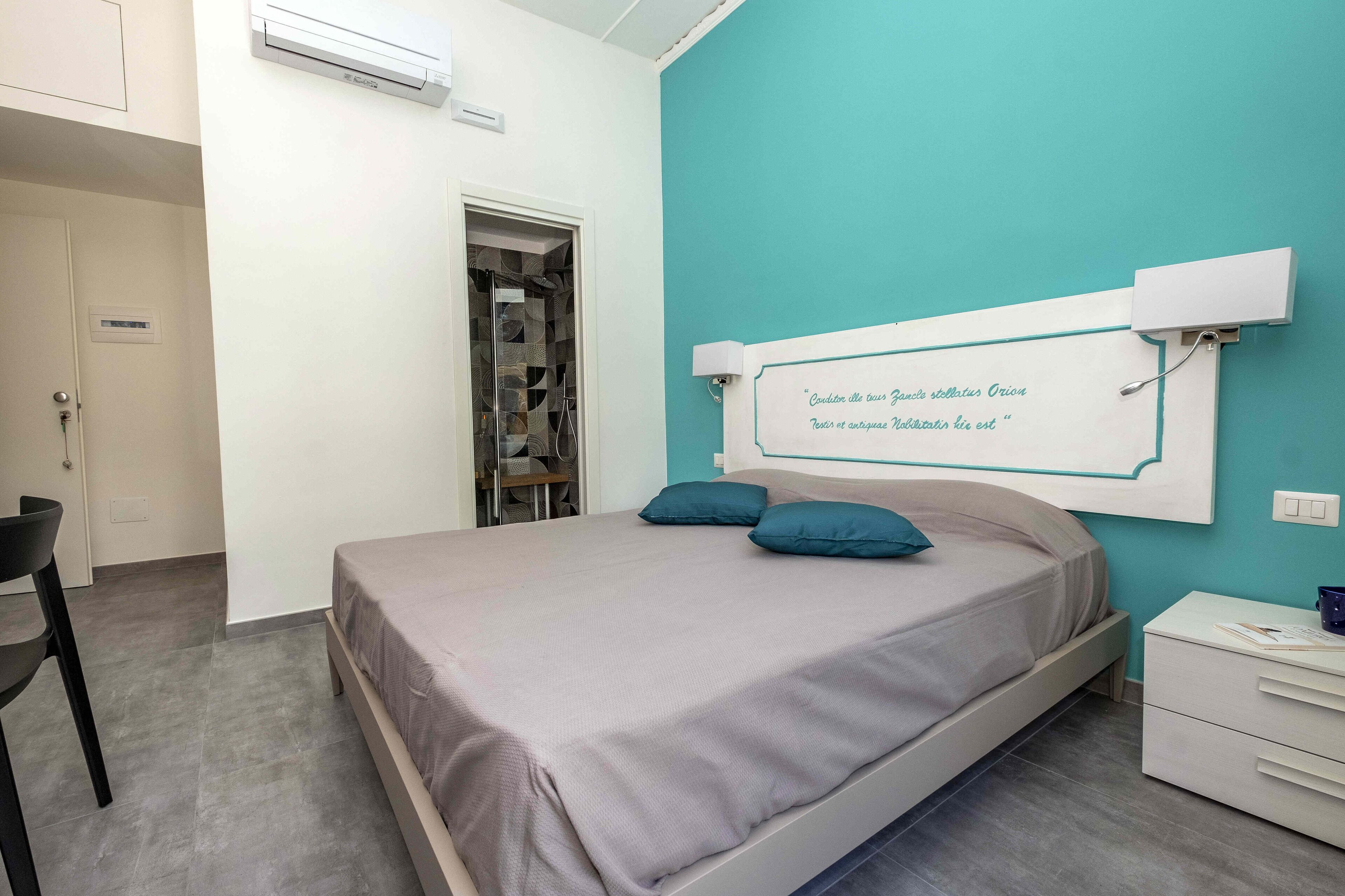 A bedroom with a bed, a nightstand, a chair, and a wardrobe.