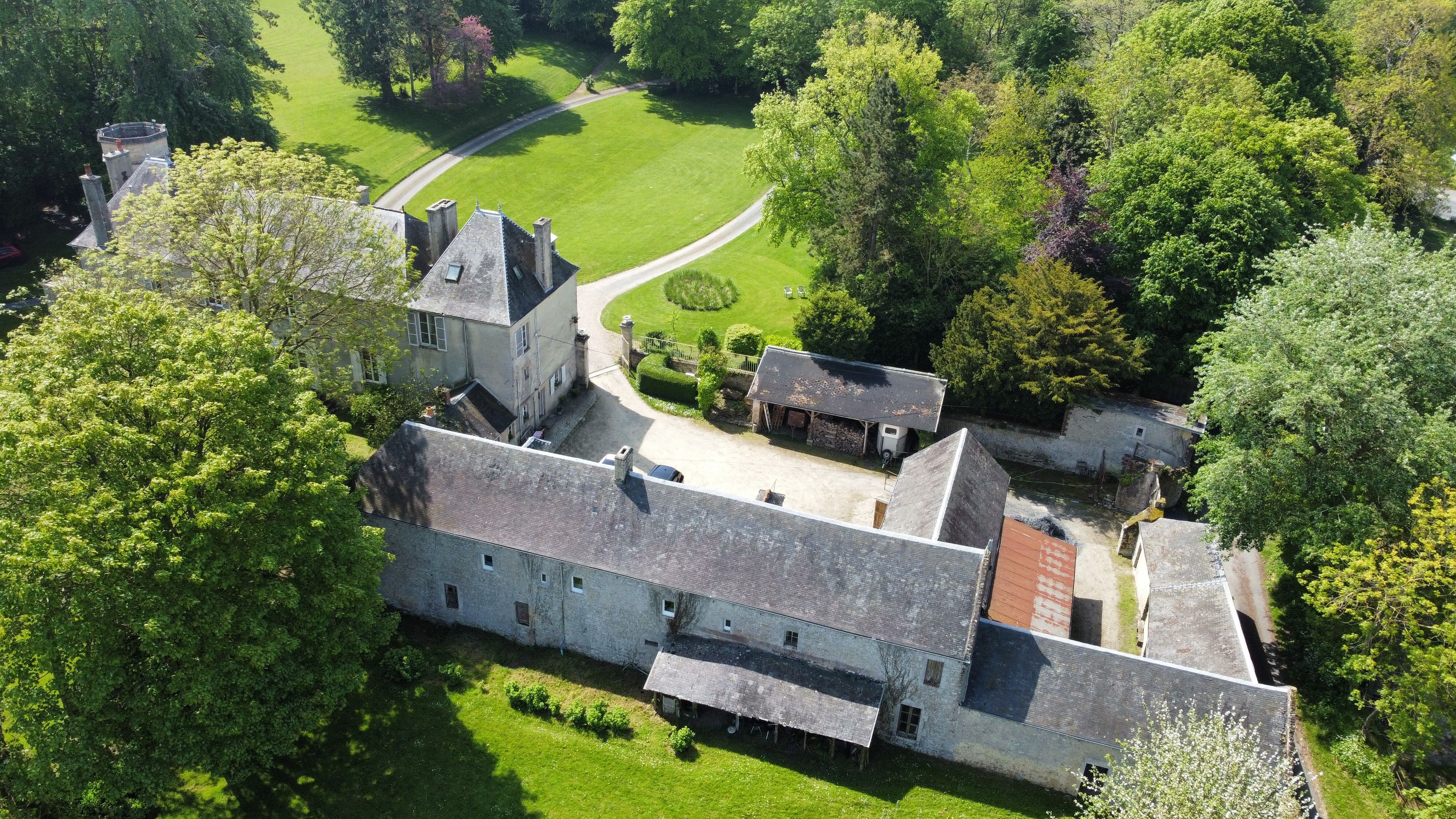 A large, historic building with a courtyard, surrounded by lush greenery.