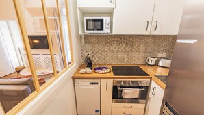Una kitchenette compacta equipada con microondas, tostadora y horno.