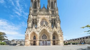 Una catedral gótica imponente con un rosetón destacado y dos torres gemelas.