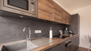 A modern kitchen with a built-in microwave, stainless steel sink, and wooden cabinets. - ★★★ Bright one-bedroom apartment in downtown Voltaire with courtyard ★★★ (Saint-Quentin)