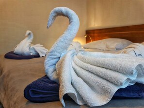 A hotel room with a bed featuring a swan-shaped towel arrangement. - Admirał I (Swinoujscie)