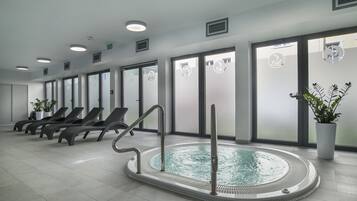 Relax by the circular pool surrounded by comfortable lounge chairs and large windows with frosted glass panels.