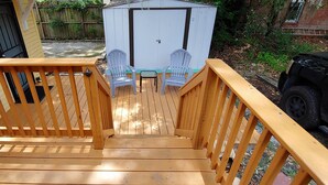 Une terrasse en bois avec un escalier menant à un patio couvert.