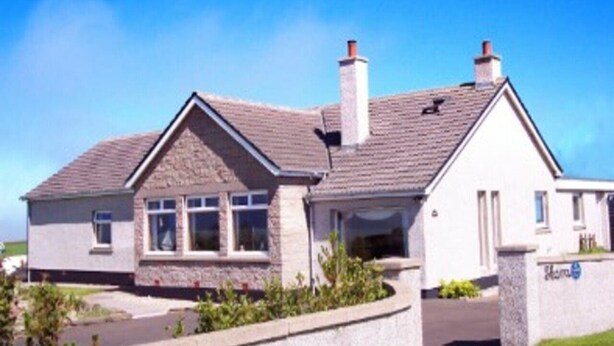 A two-story house with a stone facade, a pitched roof, and a chimney. - Skara B&B (Thurso)