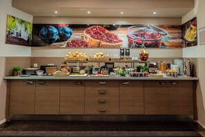 A buffet setup with various food items and condiments.