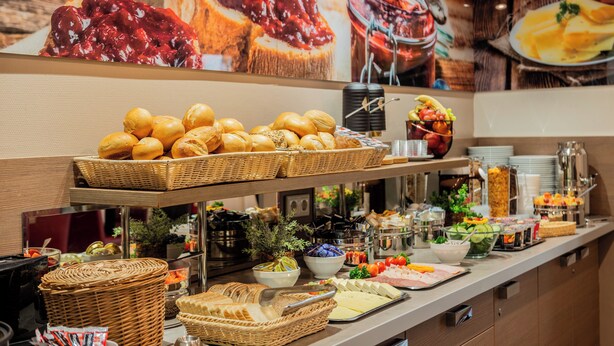 Een buffet met diverse gerechten, zoals brood, kaas en fruit.