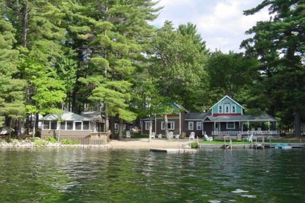 A lakeside property with a house, dock, and surrounding trees.
