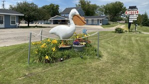 A motel with a large pelican sculpture, air conditioning, clean rooms, cabin-kitchen, cable TV, and a sign indicating the motel name. - Pelican Motel (Pelican Rapids)