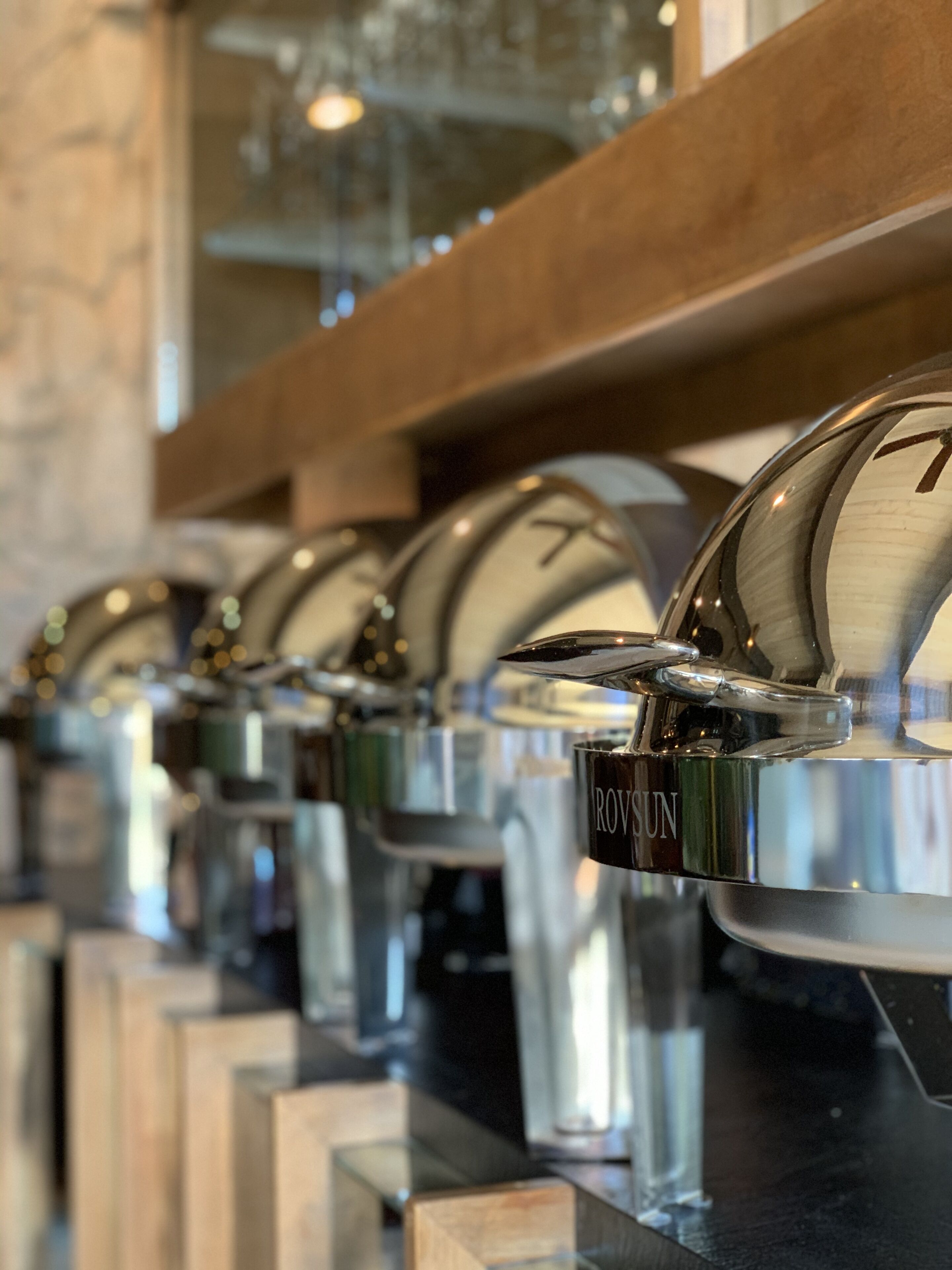 A row of stainless steel beverage dispensers with the brand name "ROUSUN" on them.