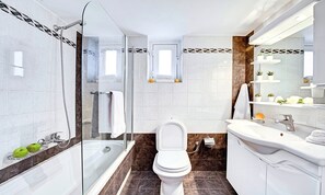 A modern bathroom with a glass-enclosed shower, a white toilet, and a vanity with a mirror.