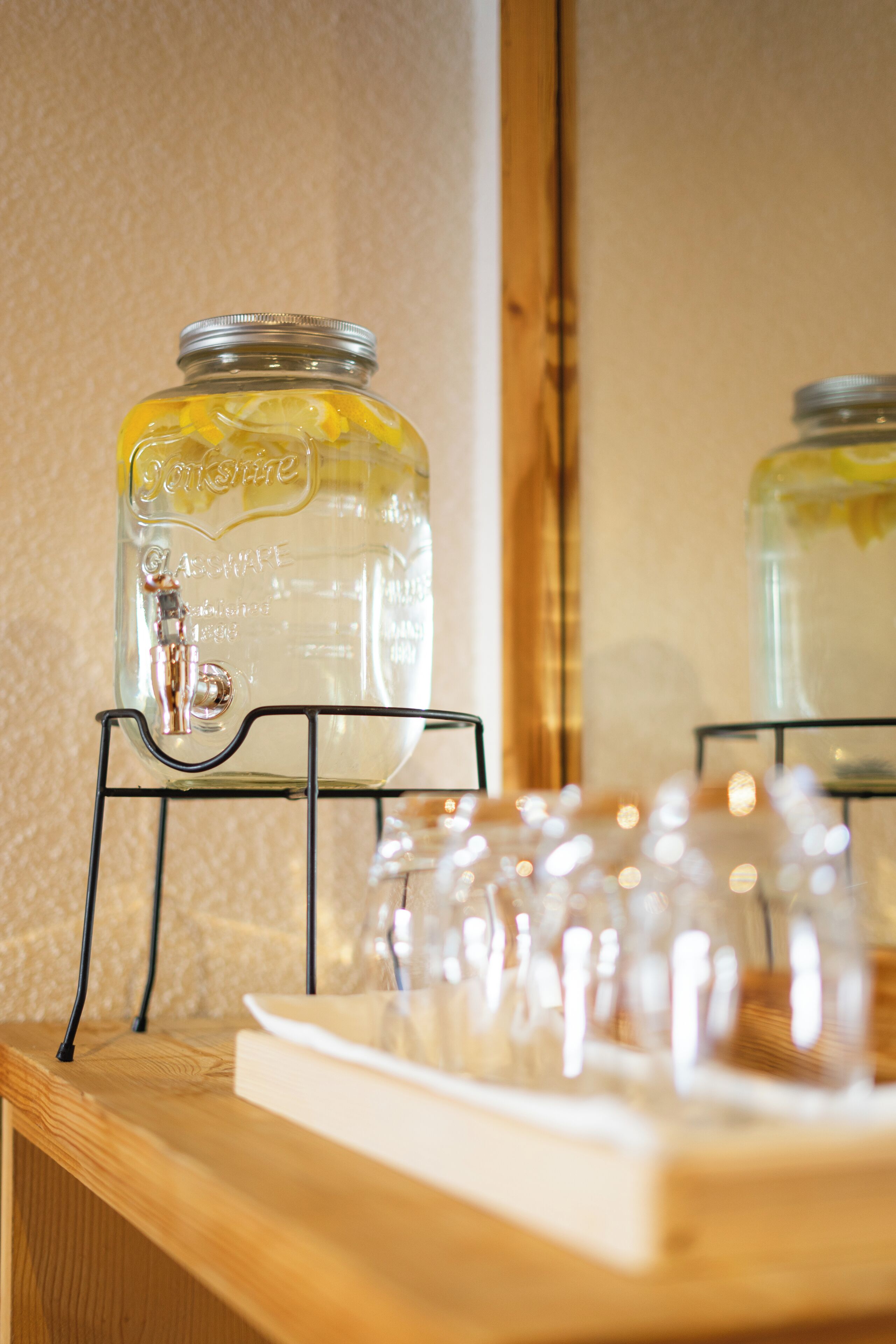 A glass jar with a metal lid on a black metal stand.