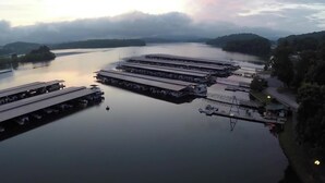 En lysthavn med flere både i havnen og en stor bygning med fladt tag.